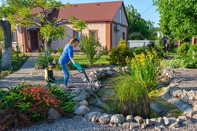 Woman doing her own pond maintenance process Woman doing her own pond maintenance process