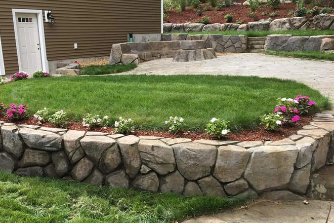 Backyard hardscape ideas include a retaining wall and driveway leading to a stone seating and firepit area Backyard hardscape ideas include a retaining wall and driveway leading to a stone seating and firepit area